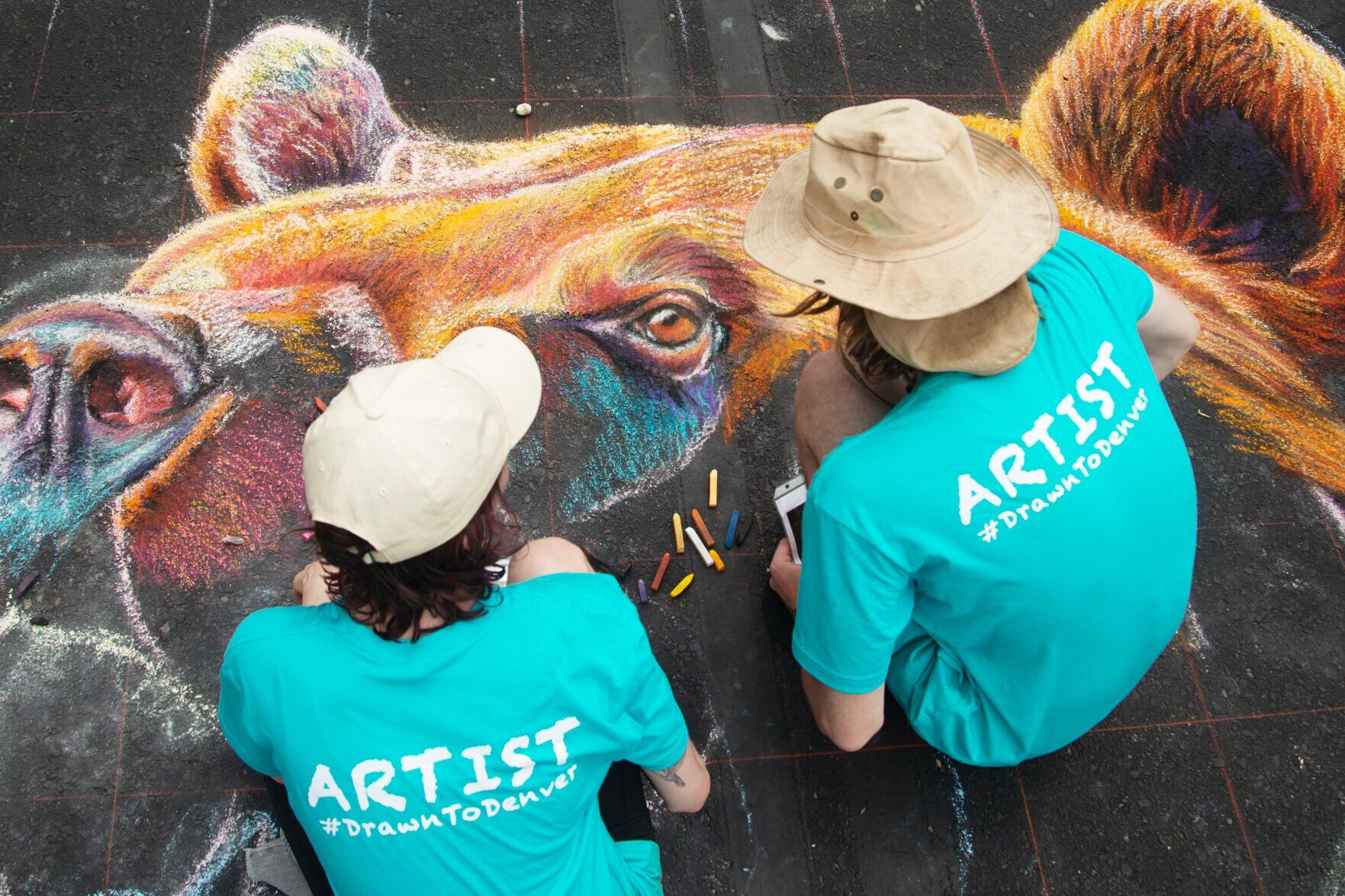 Ashe Bentley, left, and Jake Nissalke, work on a chalk bear
